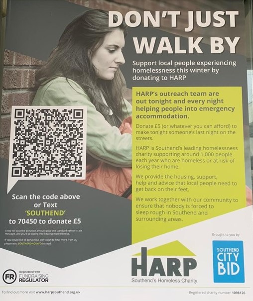 a young lady standing against a wall hugging a sleeping bag. Text and QR code around the picture asking to donate £5 for the homeless