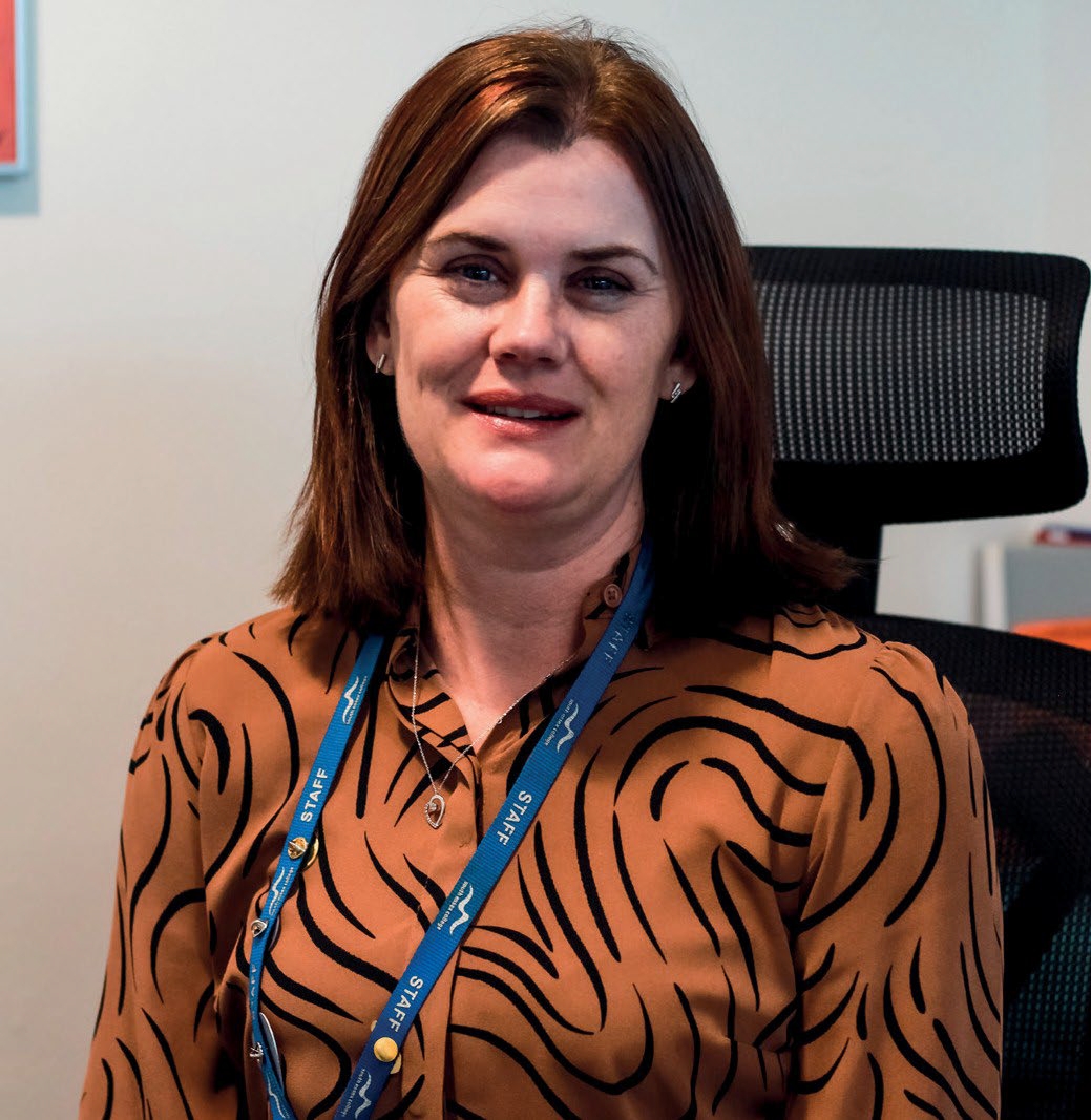 Headshot photo of lady wearing a bronze colour blouse with black print